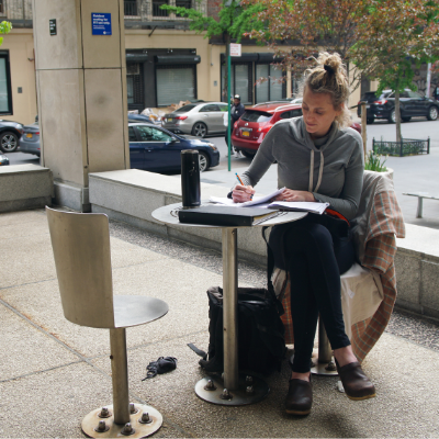 woman sitting at outside table studying