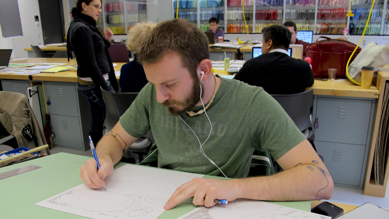 student drawing in front of wall of colored fabric swatches