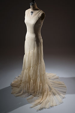 sleeveless v-neck dress with wide flared skirt and soiral ruffle from hip to train
