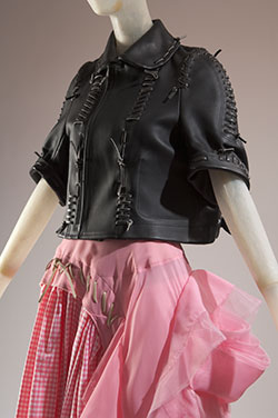 black leather biker jacket pierced with self strips in large shipstitch and saddle stitch with ballerina-inspired assymetrical pink and white full skirt