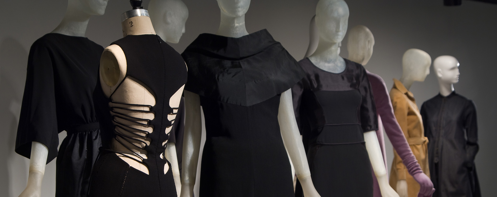 black dresses on some mannequins in the foreground with colorful dresses in the background