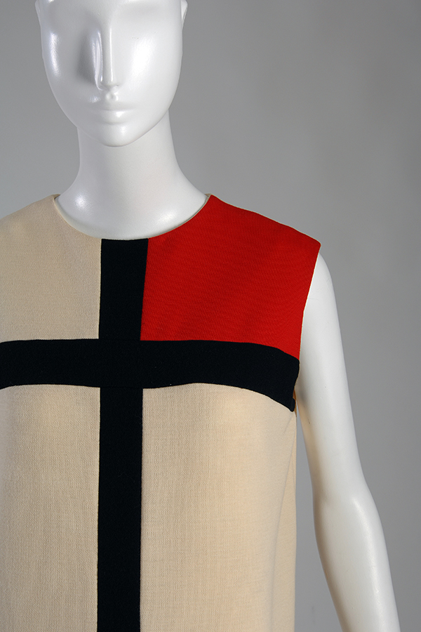 sleeveless white dress with hoizontal and vertical bands demarkating squares, one of which is filled in red