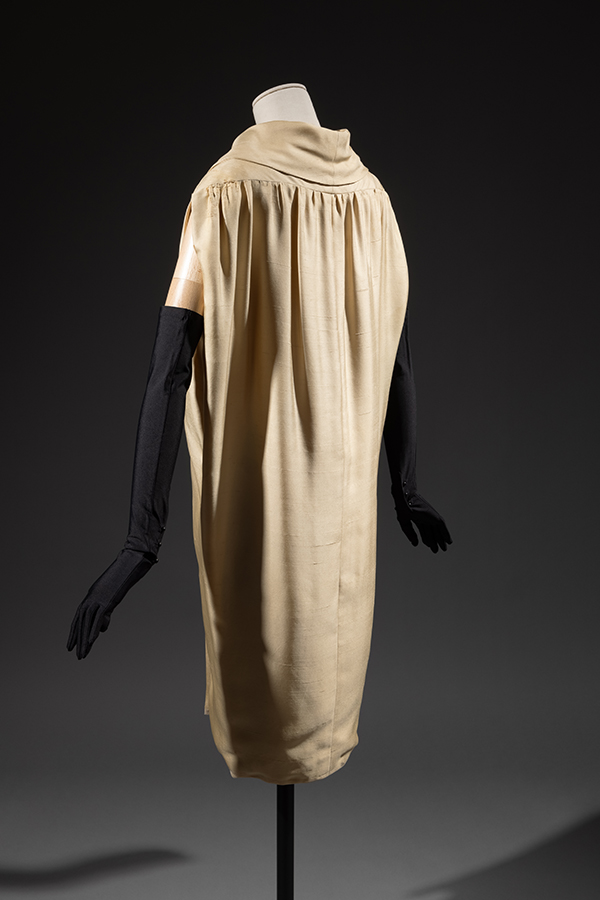 rear view of a cream-colored sack dress on a mannequin