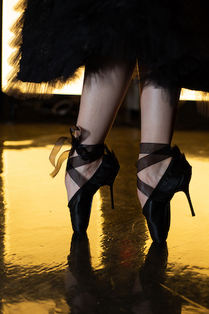 Photo of ballerina's legs in black toe shoes with ribbon