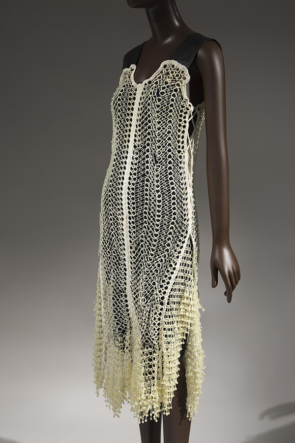 Ohne Titel off-white 3D-printed dress; plastic circular links crocheted with cotton, wide black leather shoulder straps, with black slip underneath. 