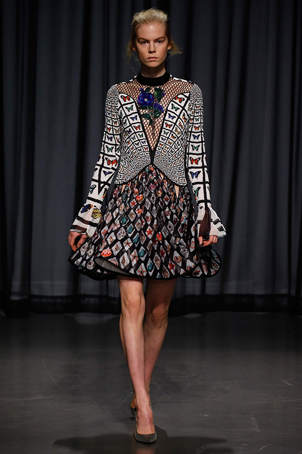 model wearing knee length, long sleeved dress with butterfly and shell print