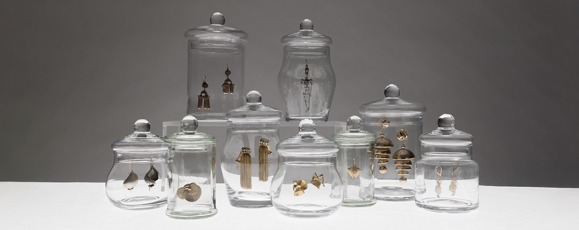various clear glass jars with earrings inside