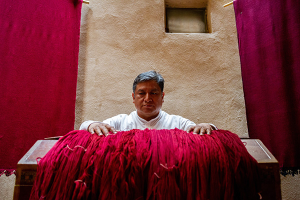 man holding vibrantly colored textile 
