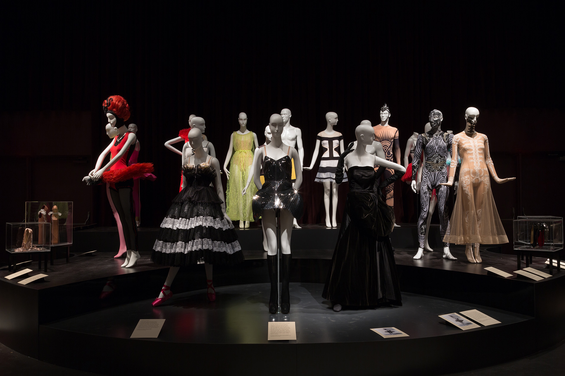 dance costumes and dance-inspired dresses on a black platform
