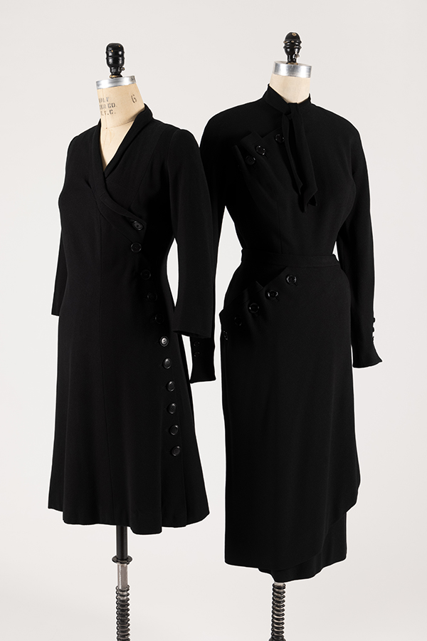 two simlar black coat dresses on dress forms