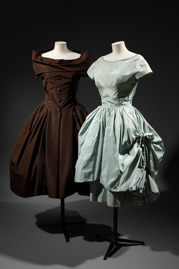 two poof-skirt dresses on mannequins. One brown, one ice blue 