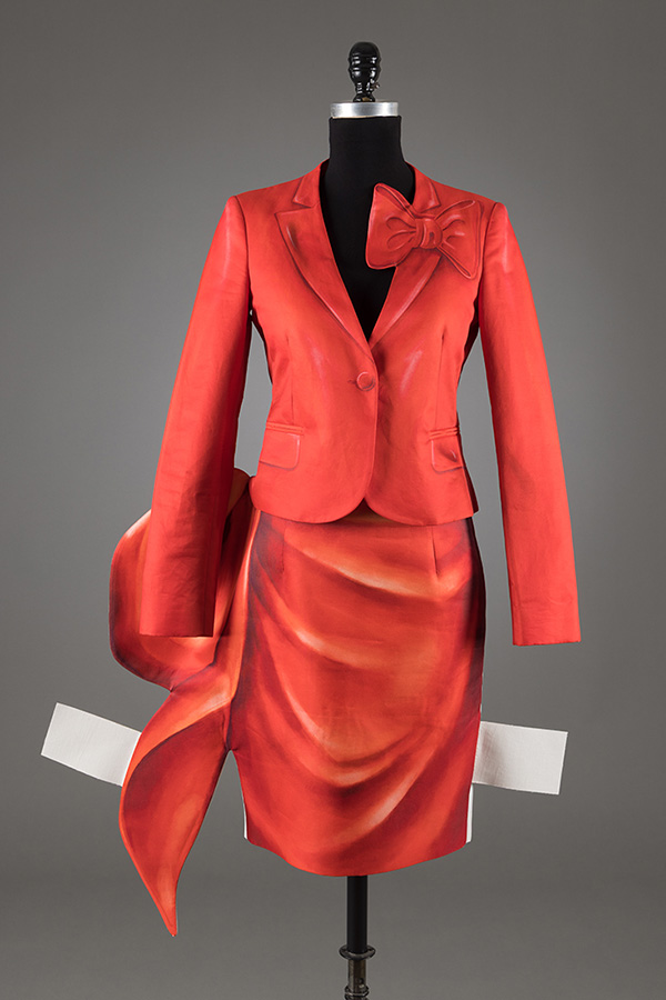 red jacket and skirt with trompe l'oeil detail and white flaps on side of skirt 