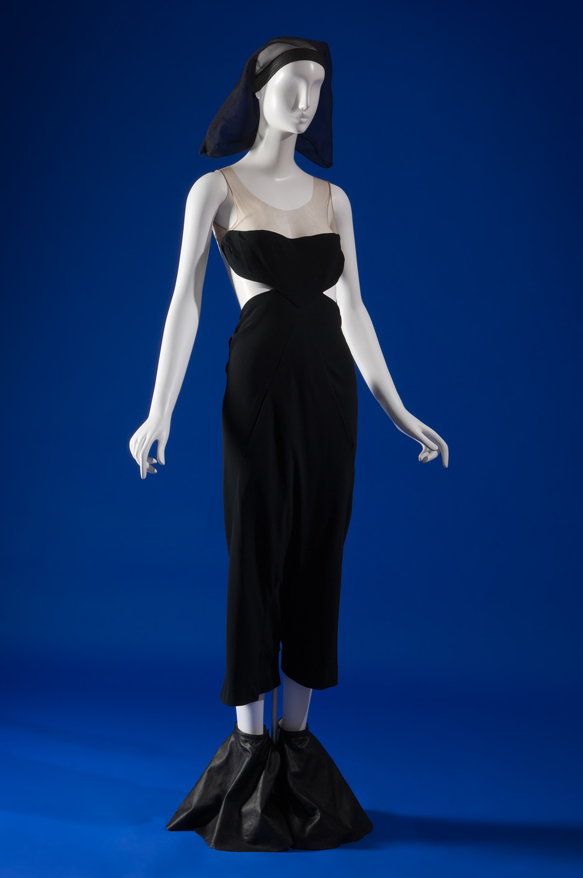 black sleeveless dress with cut outs at the side, mesh straps, styled with mesh habit