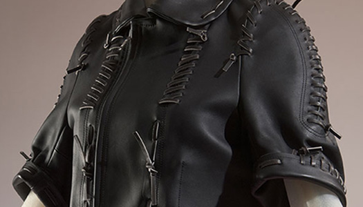 close up detail of black leather saddle-stitched, sculptural jacket by Rei Kawakubo