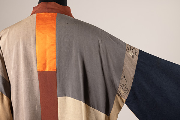 back view of a men's kimono style robe in gray, black, silver, orange, and brown color blocks