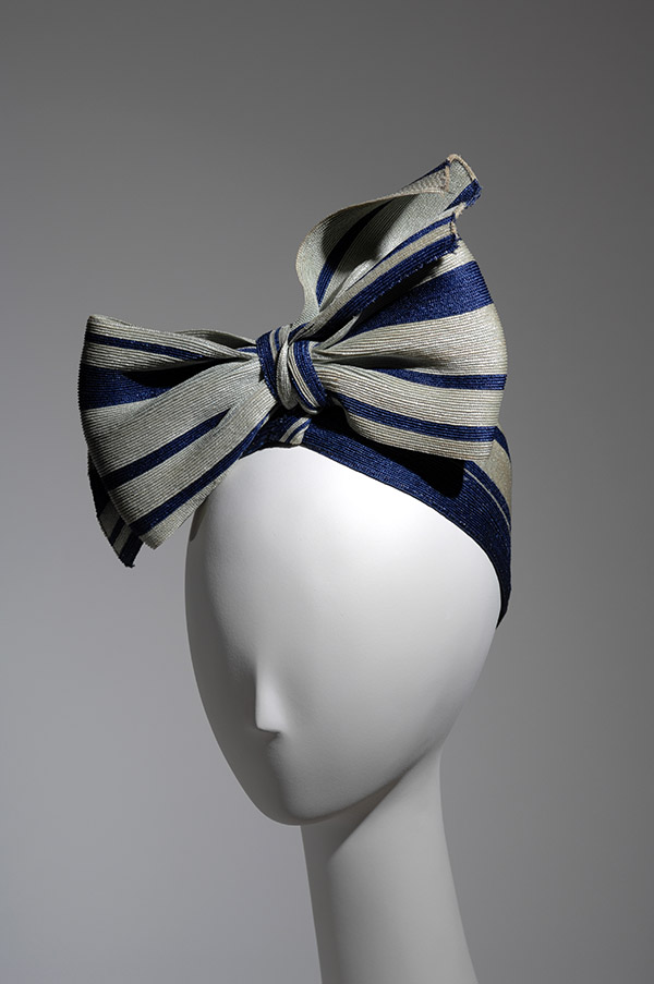 gray and navy head piece with a large bow on a mannequin head