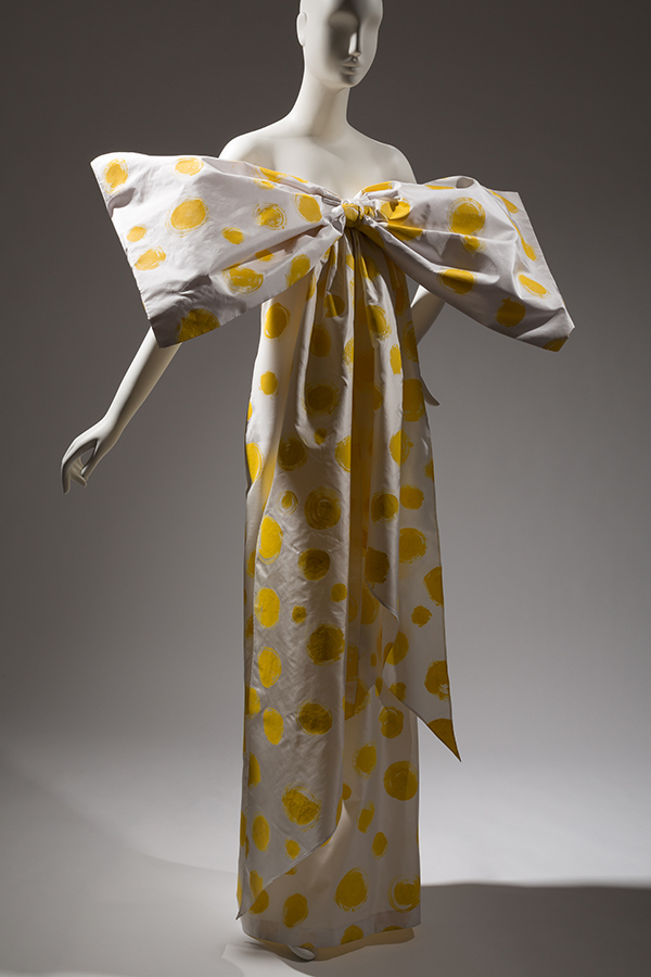 white strapless dress with yellow printed polka dots and an oversized bow tied at the bust