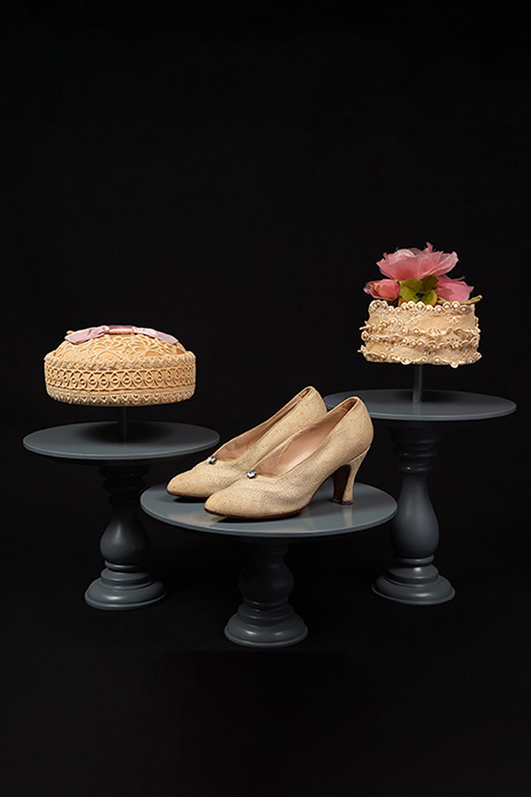 cream colored hats and a pair of heels on cake stands