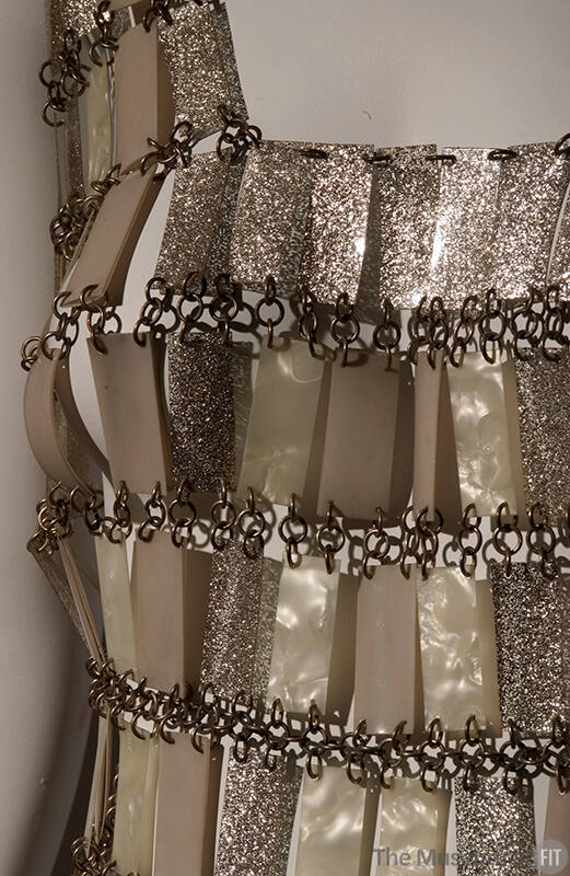 torso detail of dress made of glittery and metallic beige/gold tone rectangles chained together