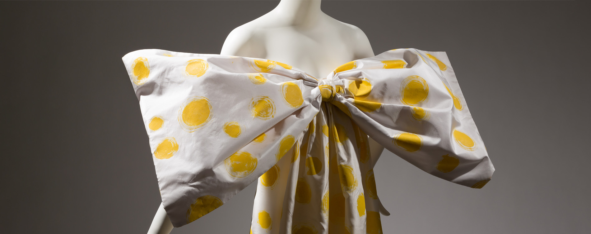 mannequin wearing ivory and yellow polka dot gown