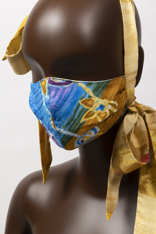 Yellow, blue, brown, green face mask with pale green cotton lining and long bow ties