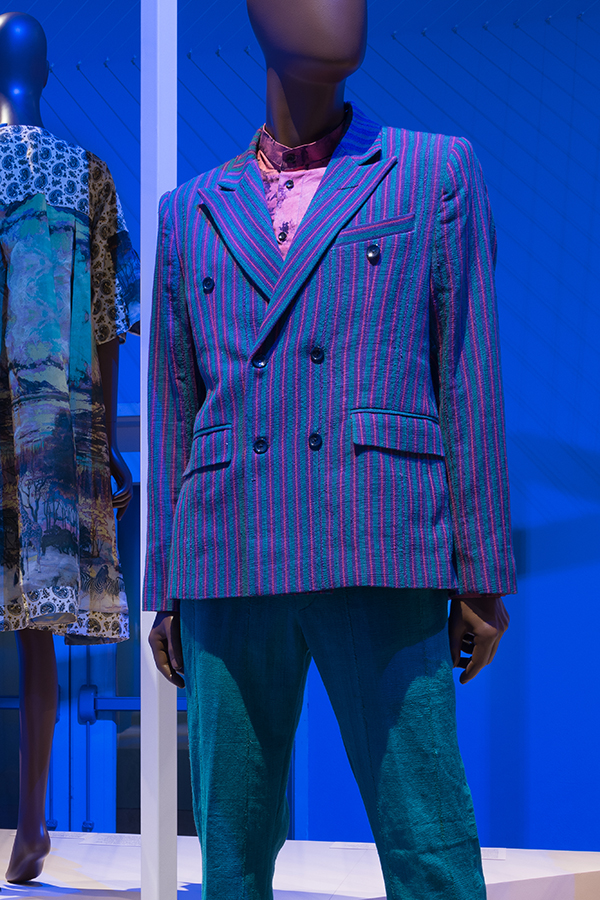 Man’s suit of green and purple striped double breasted jacket over a pink shirt and with teal pants 