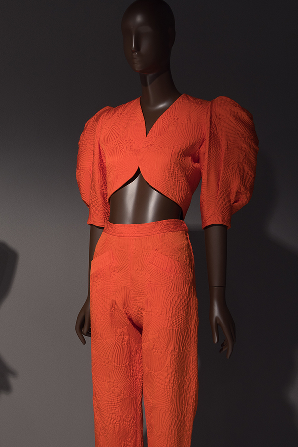 Red-orange pantsuit with bolero jacket with midriff cutaway and elbow-length puffed sleeves