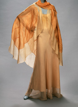 orange floor length dress with scarf draped across shoulders