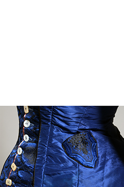 detail image of small watch pocket on left hip of royal blue bodice with black embroidery