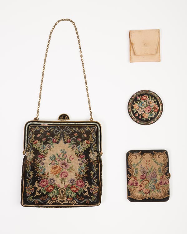small bag with floral decorations alongside three small cases