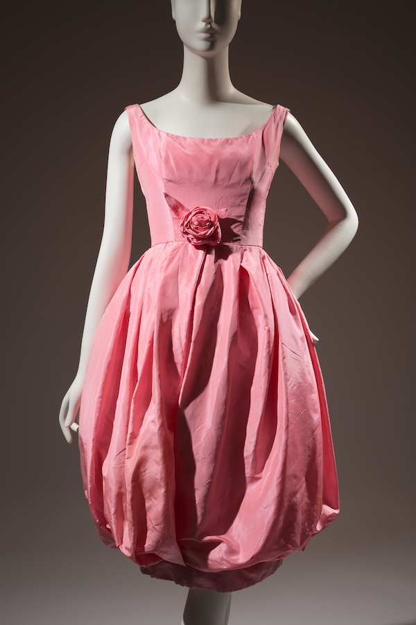 bubblegum pink sleeveless dress with puff ball skirt to the knee and fabric rosette at waisline