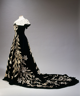 House of Worth, “Lily Dress” evening dress, black velvet with application of ivory silk in the form of lilies, embroidered with pearls and sequins, 1896. © L. Degrâces et Ph. offre/ Galliera/Roger-Viollet.