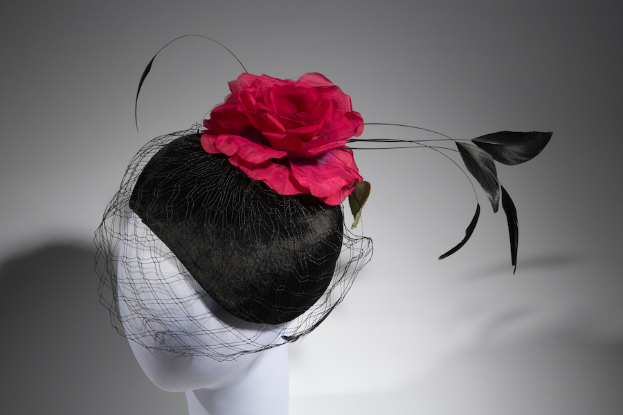 crescent hat with red silk flower on a mannequin head