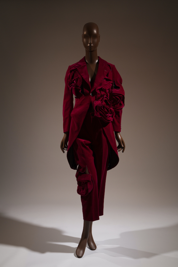 deep red velvet suit with cut-away coat with large, sculptural fabric flowers
