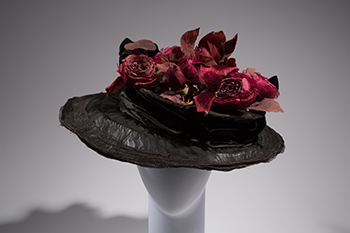 wide-brimmed hat with crown of red silk flowers on a mannequin head