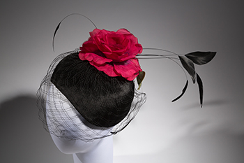 crescent hat with red silk flower on a mannequin head