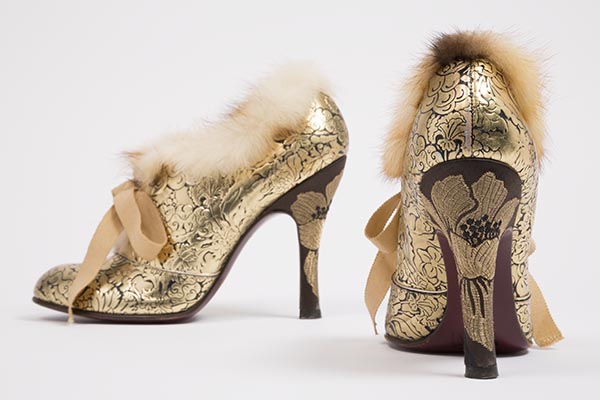 High heel oxfords with classical floral design tooled in gold metallic on black leather, trimmed with blonde and brown mink fur; round toe, high heel covered with brown, black and gold metallic brocaded silk, attached beige grosgrain ribbon ties over tongue