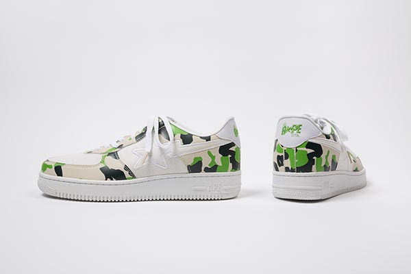 White sneakers with signature camouflage trim in dark green, neon green and tan, white canvas vamp and star stripe logo in white canvas on quarters, B*PE STA logo at counter and on white canvas tongue, CF white  lacing over tongue,  white rubber soles with molded  APE logo at outer heel.