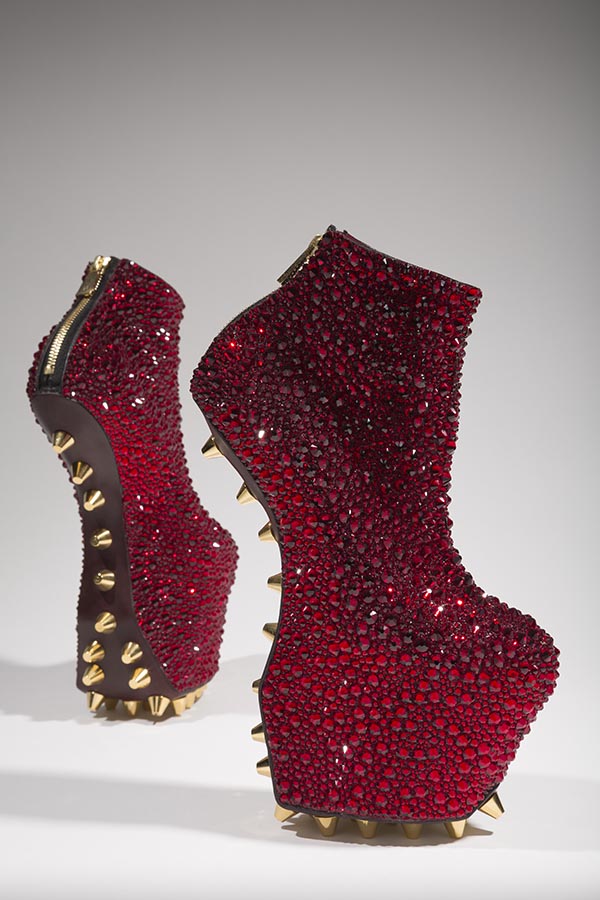 Crystal Rose ruby red heel-less platform ankle boots with pave surface in faceted crystal stones of various sizes applied to leather ground; gold studs at brown leather soles;  brass metal and black cotton tape CB zipper closure with logo pull tab