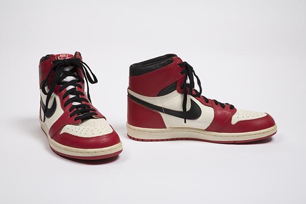 Man's high top sneakers in red, white, and black leather pieced upper with perforated vamp, Nike swoosh logo on side, and padded collar with red and white rubber sole