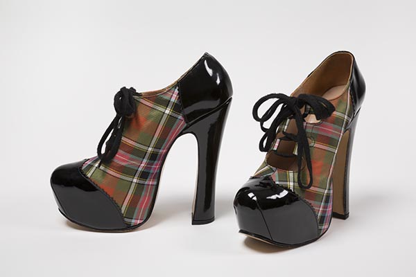 Stylized platform gillies in Bruce tartan silk twill with toecap, counter, and heel in black patent leather with pinked edges; platform sole integral with vamp, exaggerated high heel; black cotton shoelace over open throat