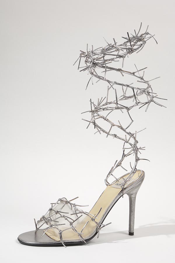 Barbed wire sandals in silver metallic leather with strands of tied leather cords across clear plastic vamp strap and forming wrap & tie ankle straps; stiletto heel