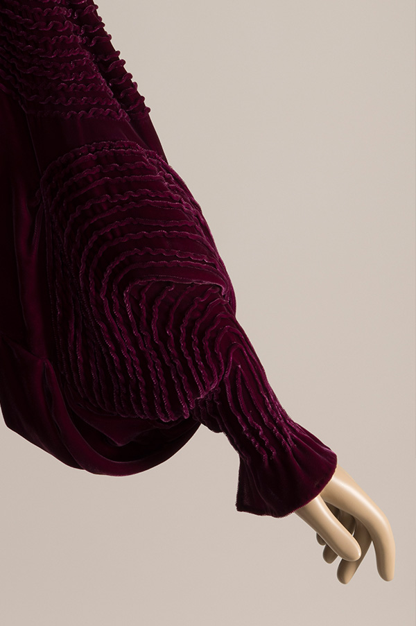violet red velvet tapered cuff, and elaborate pin-tucks in concentric circles.