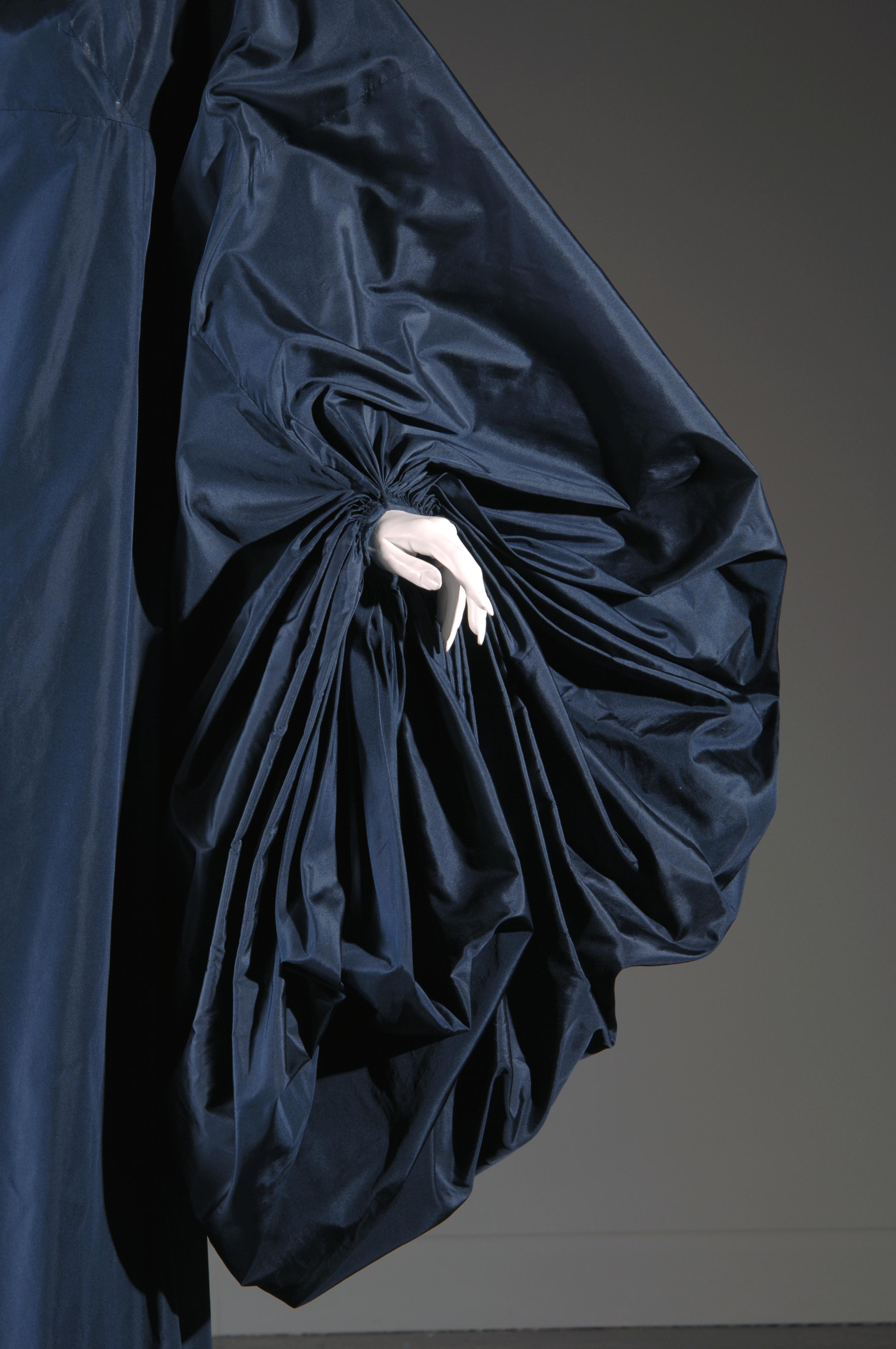 detail image of the textured oversized puff sleeve of a navy silk gown