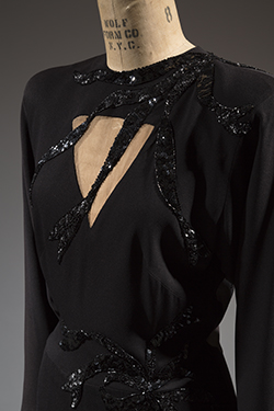 detail of Adrian black silk dress with a triangle keyhole