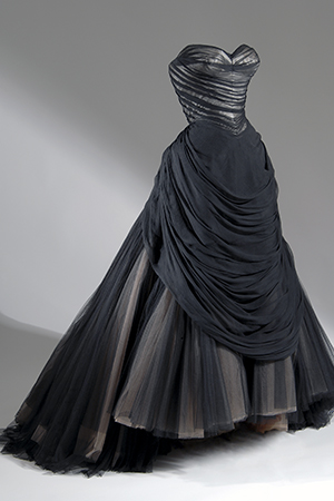 strapless bodice in black chiffon over white satin with floor length skirt with layers of black, brown and beige netting gathered into back bustle and forming wide apron front